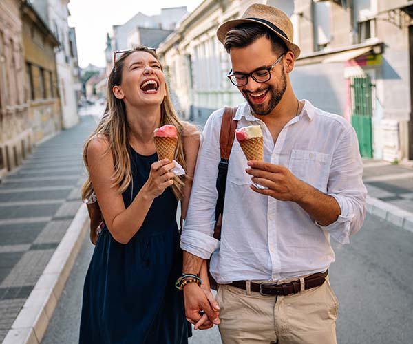 Двойка се смее с сладолед в ръка.