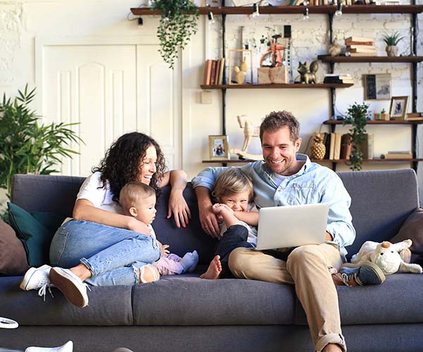 Щастливо семейство с деца купува туристическа застраховка на онлайн.