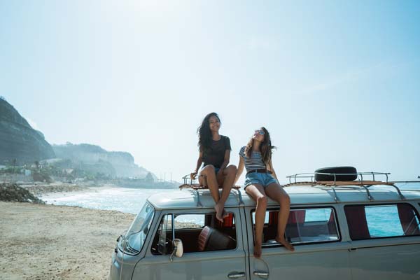 Две жени на плажа, седнали на ван