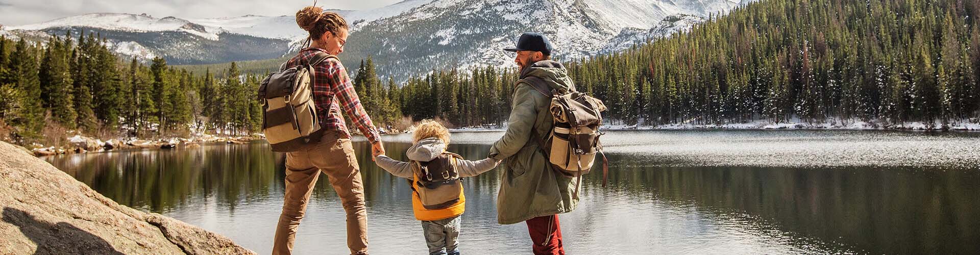 Семейство с дете, държащи се за ръце по време на ваканция на в планините