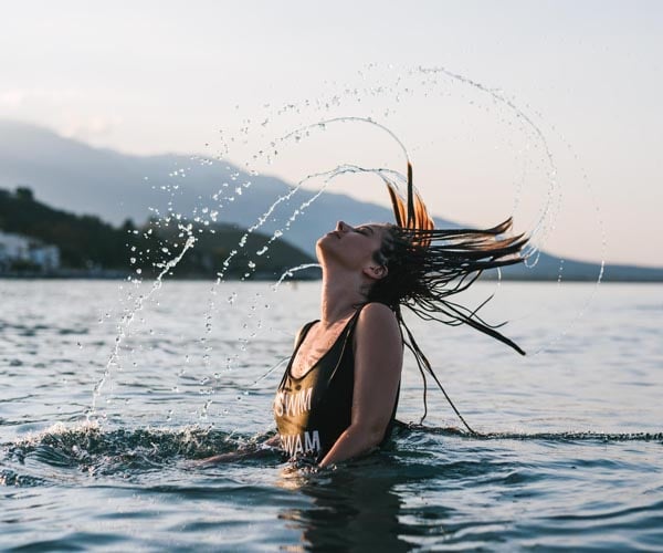 жена в море, премята косата си