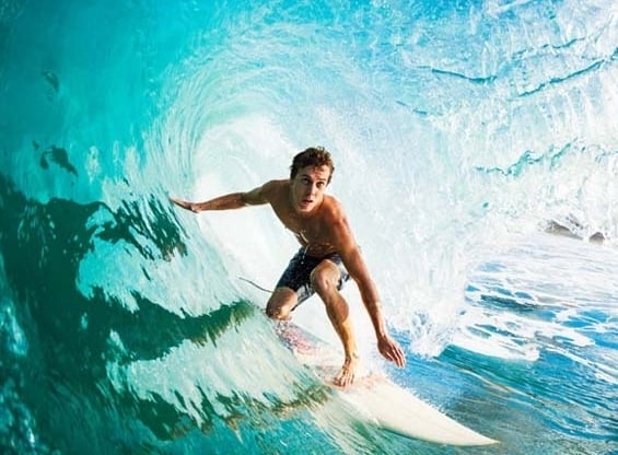 Мъж на сърф под вълна