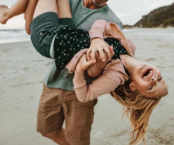 Баща с дъщеря играят на плаж