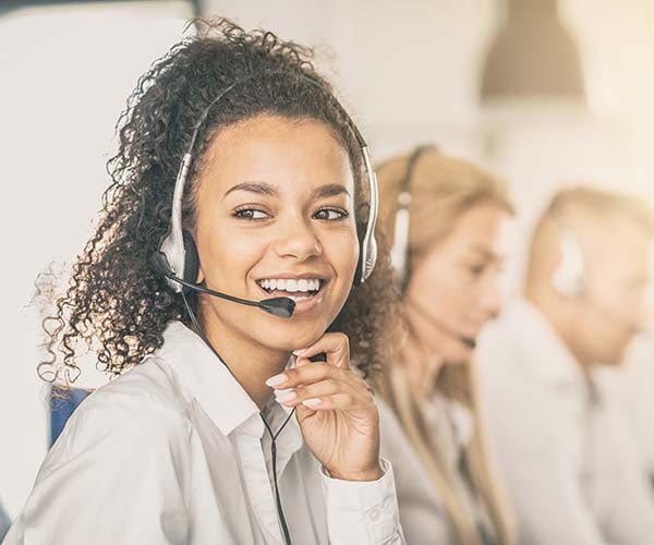 Служителка в център за обслужване на клиенти със слушалки.