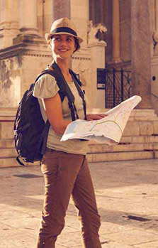 Усмихната жена с туристическа карта в ръка, застрахована с туристическа застраховка