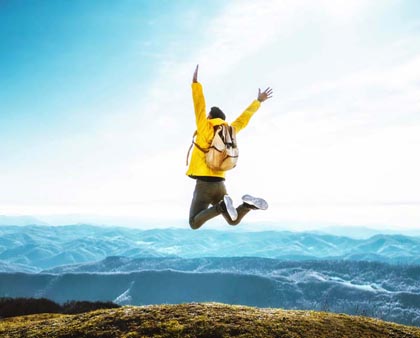Планински турист, скачащ във въздуха от радост