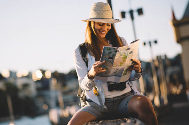 Жена на почивка в чужбина, разглеждаща туристическа карта